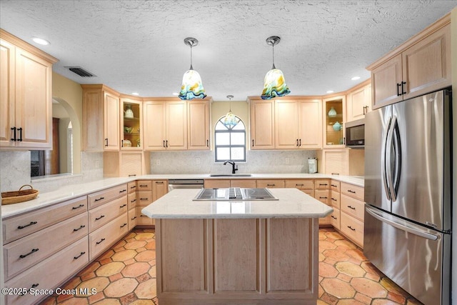 kitchen featuring light brown cabinetry, sink, pendant lighting, and appliances with stainless steel finishes