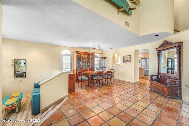 tiled dining room featuring a textured ceiling