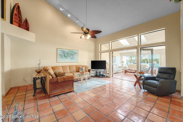 tiled living room featuring track lighting, a textured ceiling, and high vaulted ceiling