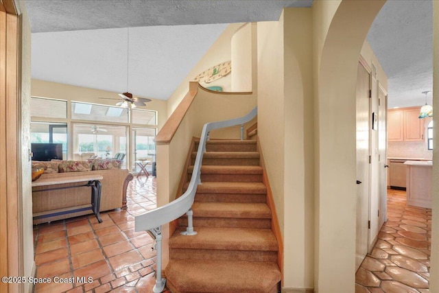 stairway featuring tile patterned floors, a textured ceiling, and ceiling fan