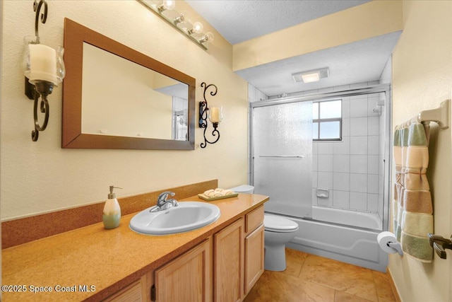 full bathroom with combined bath / shower with glass door, vanity, toilet, tile patterned floors, and a textured ceiling