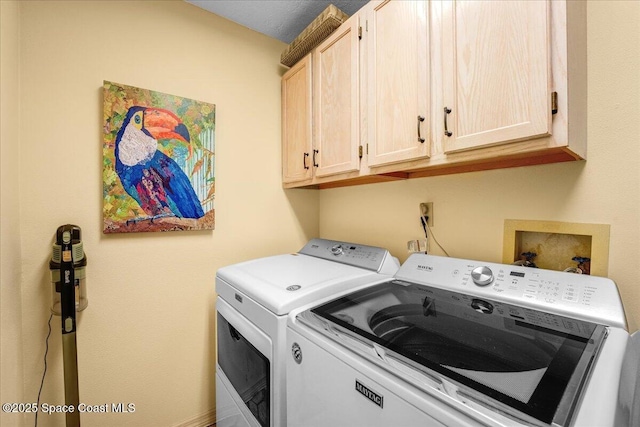 laundry room featuring cabinets and washing machine and clothes dryer