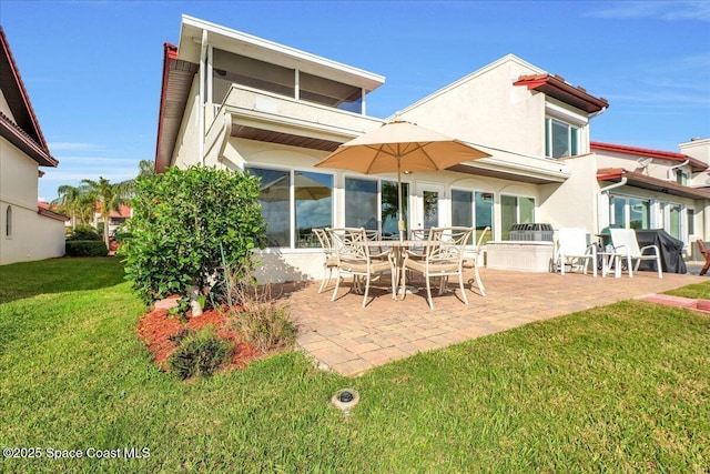 back of property featuring a patio area and a lawn