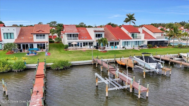 dock area featuring a water view, a yard, and a patio