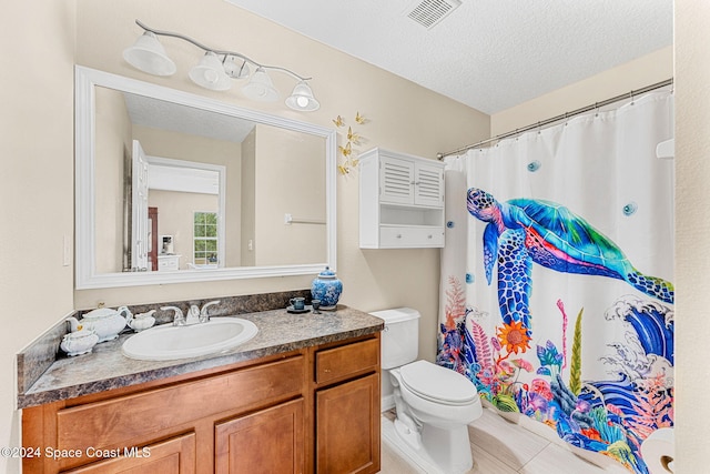 bathroom with tile patterned floors, vanity, toilet, and a textured ceiling