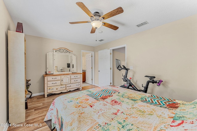 bedroom with ceiling fan, light hardwood / wood-style flooring, and a textured ceiling