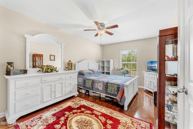 bedroom with ceiling fan, dark hardwood / wood-style flooring, and a textured ceiling