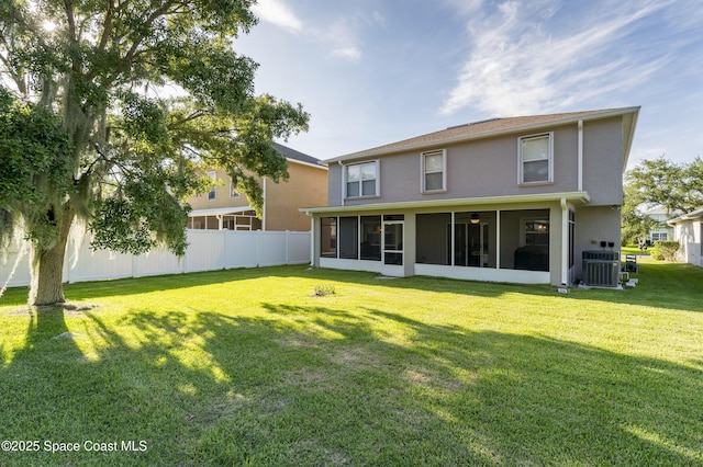 rear view of property featuring a sunroom, cooling unit, and a lawn