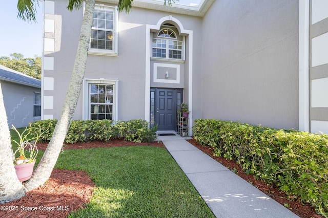 view of exterior entry with a yard