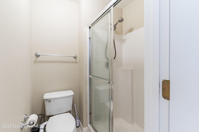 bathroom featuring an enclosed shower and toilet