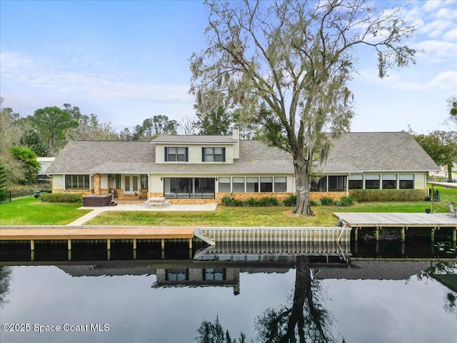 rear view of house featuring a water view, a jacuzzi, and a patio area