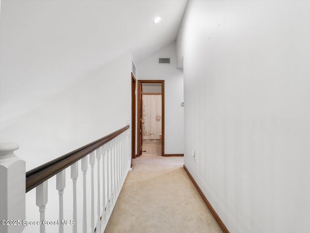 hallway with light carpet and high vaulted ceiling