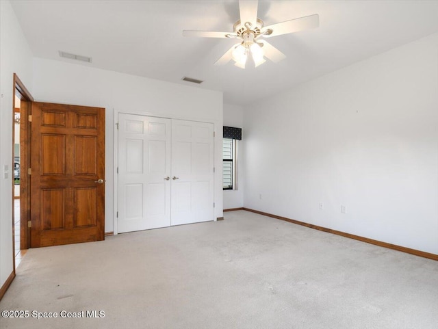 unfurnished bedroom with ceiling fan, light colored carpet, and a closet