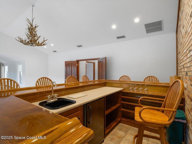 kitchen featuring sink, vaulted ceiling, and a chandelier