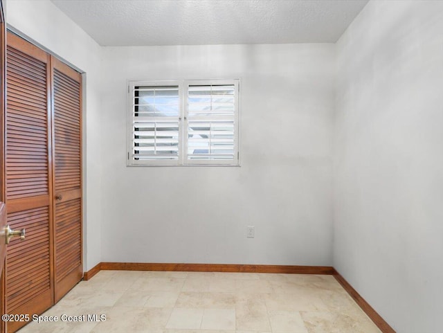 unfurnished room with a textured ceiling