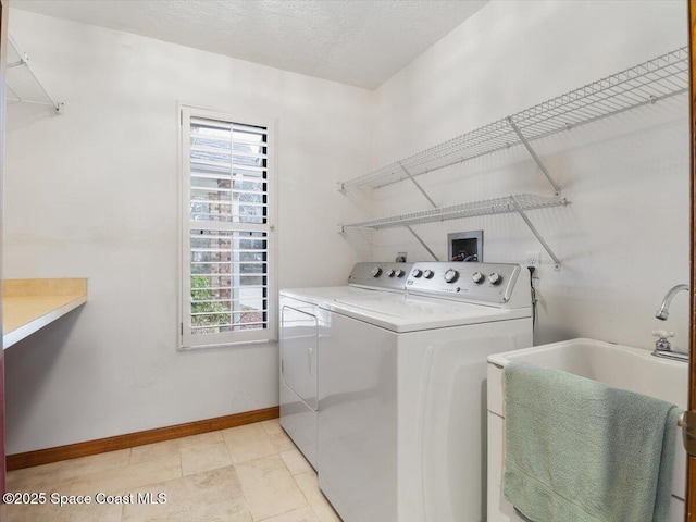 laundry room featuring independent washer and dryer, sink, and a textured ceiling