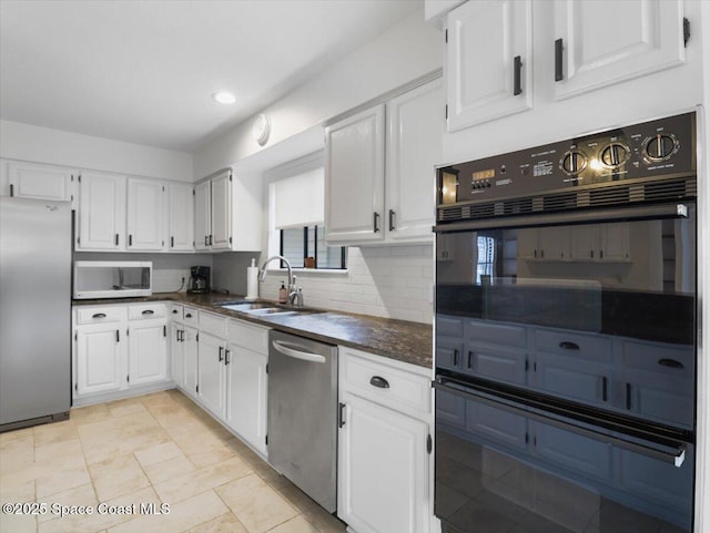 kitchen featuring stainless steel appliances, sink, decorative backsplash, and white cabinets