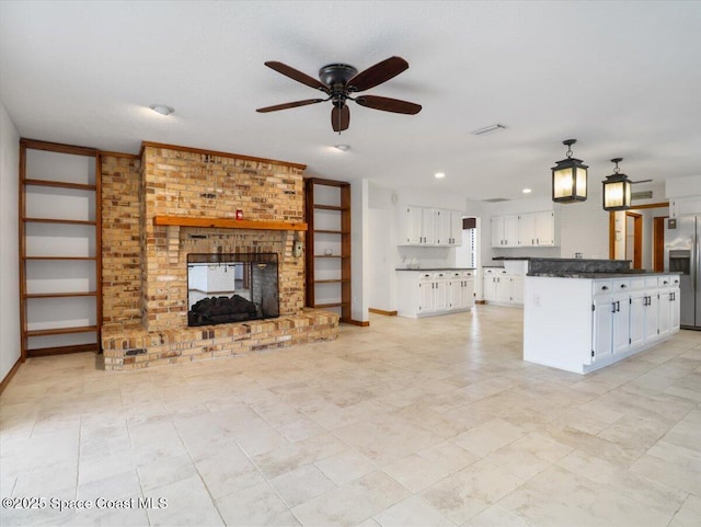 kitchen with white cabinetry, stainless steel fridge with ice dispenser, decorative light fixtures, and a brick fireplace