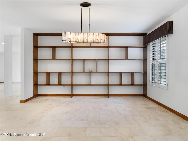 unfurnished room with a notable chandelier