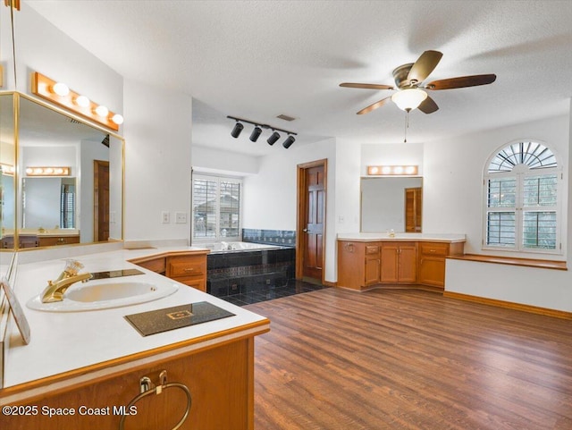 bathroom featuring a textured ceiling, vanity, a bathtub, ceiling fan, and hardwood / wood-style floors