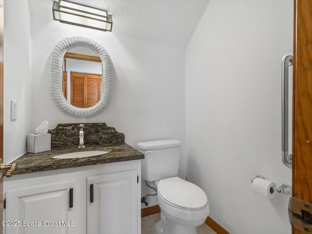 bathroom with vanity, a textured ceiling, and toilet