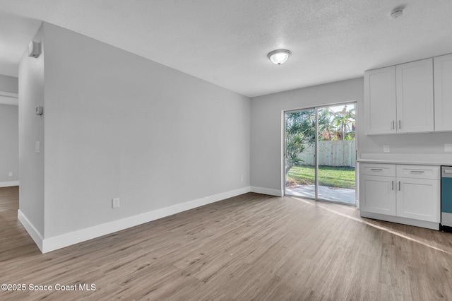 unfurnished dining area featuring light hardwood / wood-style floors and a textured ceiling