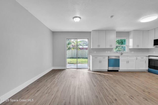 kitchen with sink, a textured ceiling, light wood-type flooring, stainless steel appliances, and white cabinets