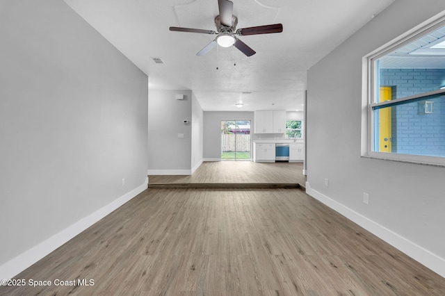 unfurnished living room featuring ceiling fan and light hardwood / wood-style floors