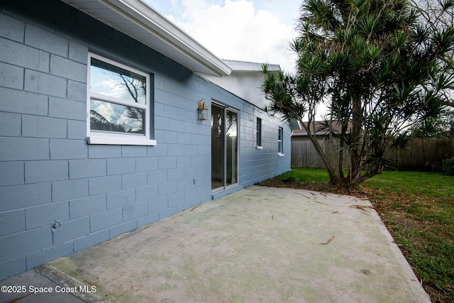 view of side of home with a yard and a patio area