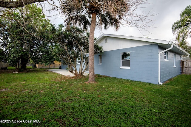 view of side of home featuring a yard and a patio area