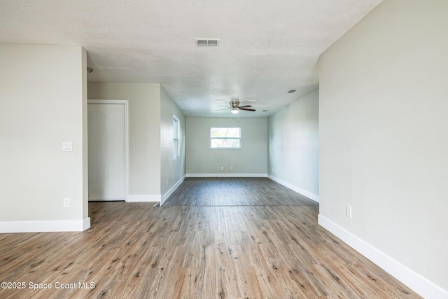 unfurnished room featuring a textured ceiling, ceiling fan, and light wood-type flooring