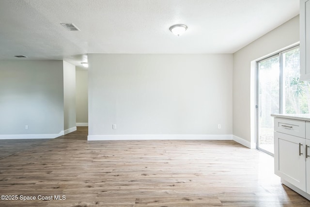 empty room featuring a textured ceiling and light wood-type flooring