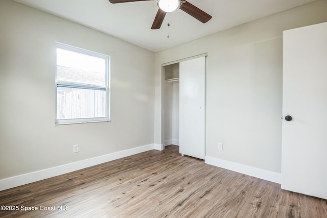 unfurnished bedroom featuring ceiling fan, a closet, and light wood-type flooring