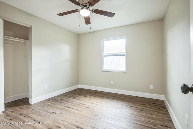 unfurnished bedroom featuring ceiling fan, light wood-type flooring, and a closet