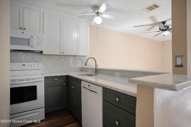 kitchen with white cabinetry, white appliances, kitchen peninsula, and sink