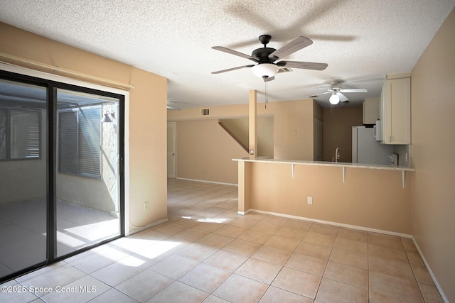 empty room featuring light tile patterned floors, sink, and a textured ceiling