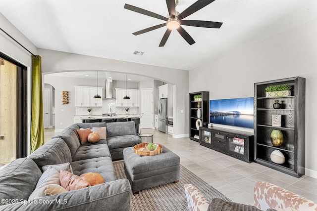 living room with sink, light tile patterned floors, and ceiling fan