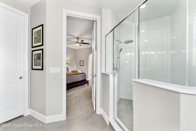 bathroom with ceiling fan, a shower with shower door, and tile patterned flooring