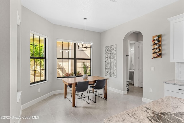 dining area featuring light tile patterned floors and a chandelier