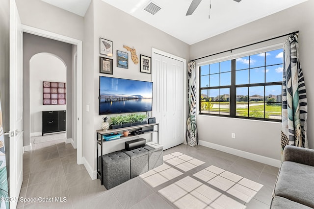 tiled living room with ceiling fan