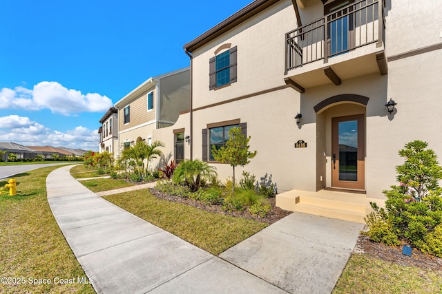 exterior space with a balcony and a yard