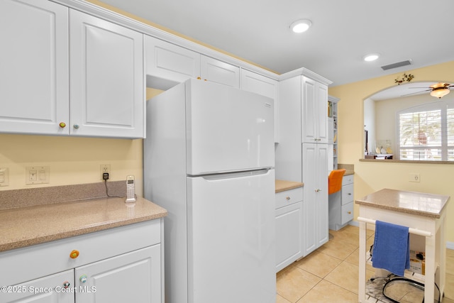 kitchen with white cabinetry, light tile patterned floors, ceiling fan, and white refrigerator