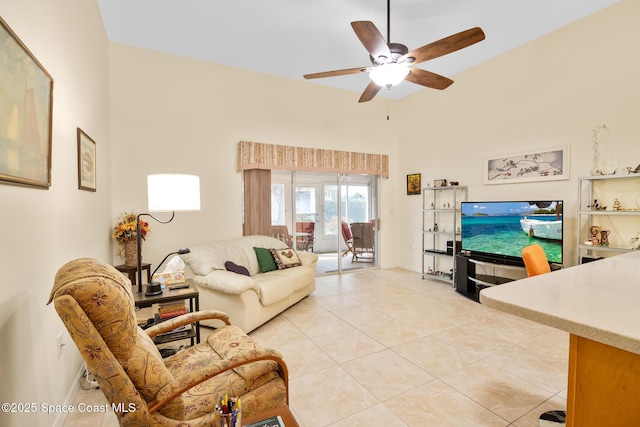 tiled living room with ceiling fan and a high ceiling