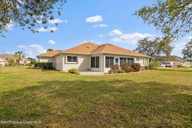 rear view of property with a lawn and a patio