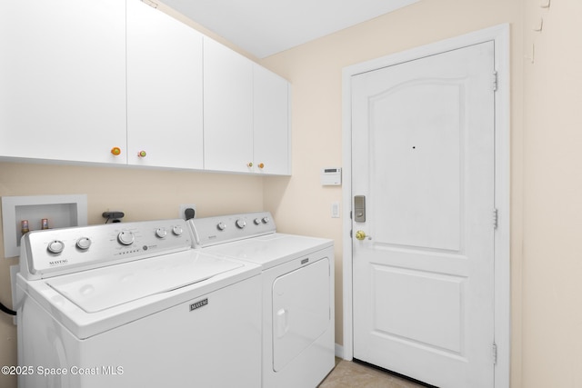 washroom with independent washer and dryer and cabinets