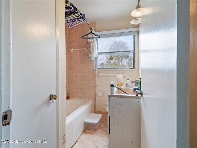 full bathroom featuring vanity, tiled shower / bath combo, and toilet