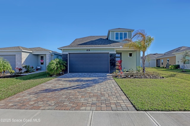 view of front of property featuring a garage, a front yard, and central air condition unit