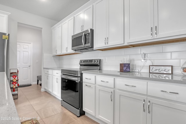 kitchen with backsplash, appliances with stainless steel finishes, light stone countertops, and white cabinets