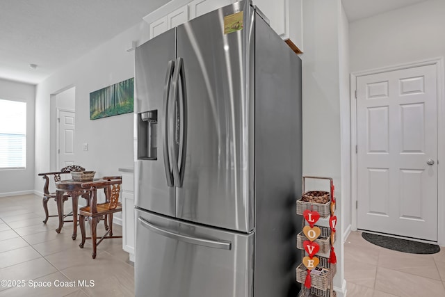 kitchen with white cabinetry, stainless steel refrigerator with ice dispenser, and light tile patterned flooring