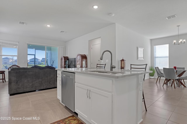 kitchen featuring sink, decorative light fixtures, a center island with sink, stainless steel dishwasher, and white cabinets